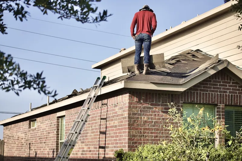Professional roofer working on a residential roof in Bettendorf